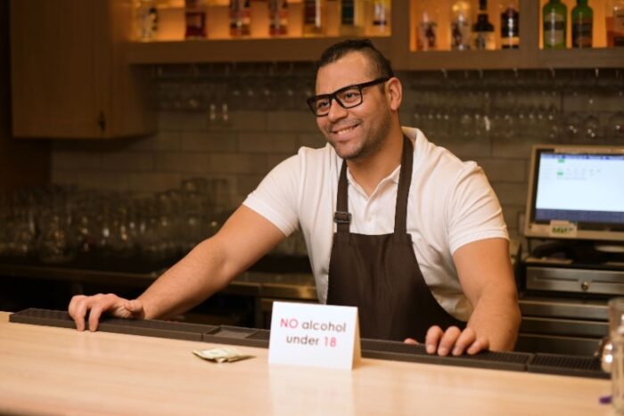 Bartender en restaurante negando la venta de alcohol a menores de 18 años